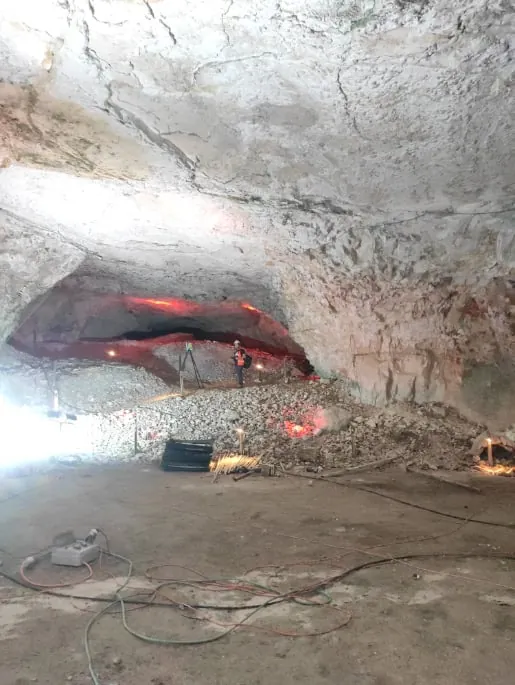 ציוד מדידה ותאורה על רצפת המערה, מתחת לתקרת הסלע