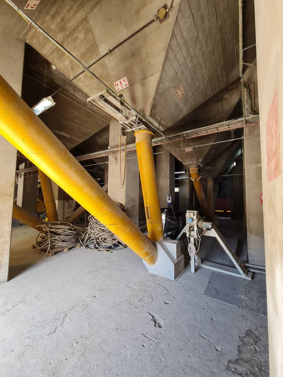 צינורות צהובים ומשפכי בטון בקומה התחתונה של הממגורה